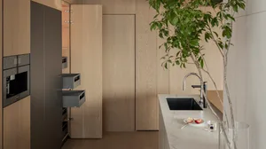 Modern minimalist kitchen featuring a marble countertop and wooden cabinets.
