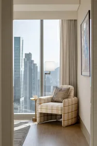 A cozy urban residential space with a comfortable chair, curtains, and a modern floor lamp.