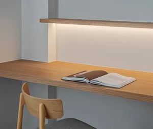 An open book on a modern, floating desk with ambient lighting in a minimalist home office setting.