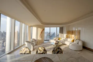 A modern living room with white marble and white leather furniture.