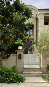 Concrete steps and gate leading to a residential home's entrance surrounded by greenery.