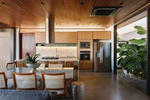 A modern kitchen with white marble countertops and wood cabinets.