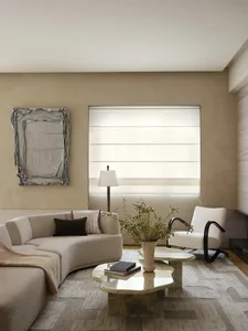 Modern minimalist living room with neutral-toned furniture, a round marble coffee table, a floor lamp, and a white vase of fl