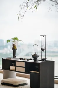 A minimalist-style tea table with ceramic decorations and a metal incense burner.