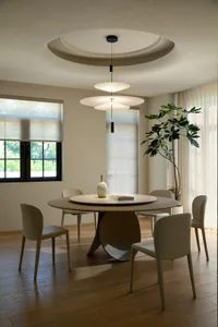 Modern dining room featuring white pendant lights, wooden furniture, and a green plant.