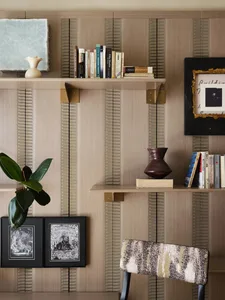 A modern office with a bookshelf, chair, and decorative vases.