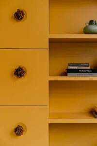 A modern interior with a metal shelf containing books and decorative objects.