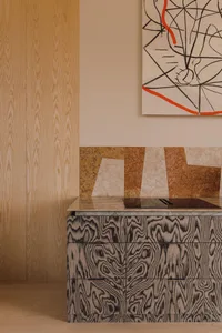 Modern kitchen featuring a marble countertop and wooden cabinets.