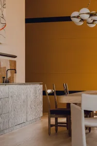 A modern kitchen with white marble countertops and wooden elements.