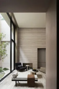Modern living room featuring a glass wall, minimalist furniture, and a sleek design.