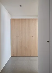 A minimalist closet with wooden doors and sleek design.