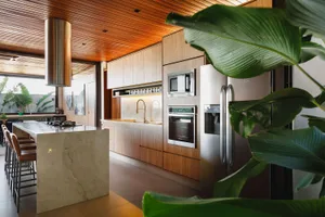 Modern, minimalist kitchen featuring marble countertops and wood cabinetry.