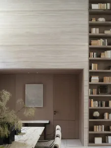 A modern minimalist library with wooden walls and shelves filled with books, featuring a minimalist door and a wooden table.