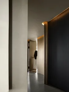 A modern bedroom featuring minimalist design principles with a combination of wood and concrete materials.