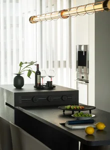 A sleek, modern kitchen counter featuring a black metal surface with a dark wooden base, illuminated by an industrial-style h