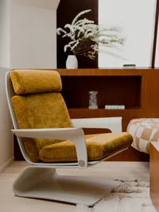 A minimalist modern living room with a yellow cushioned chair.