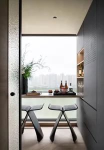 Modern bar stools with black legs and high silver backs.