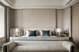 A modern bedroom with a fabric headboard and pillows, complemented by two nightstands and lamps.