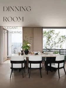 Modern dining room with a sleek marble table and upholstered chairs, featuring elegant decor and a large window for natural l
