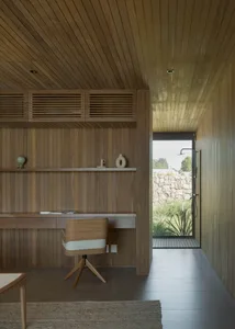 A modern home office featuring wooden walls and a desk area.