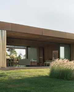 A modern living room with large windows and a wooden exterior.