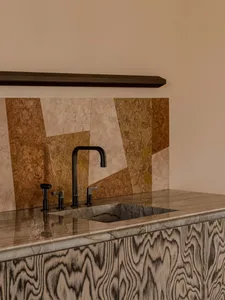 A minimalist kitchen with a marble countertop and sink.