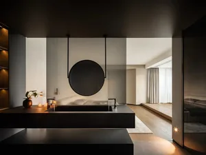 A modern minimalist bedroom with a sleek desk, wooden floor, and white décor.