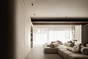Contemporary minimalist living room featuring modern, neutral-toned seating and soft textiles.