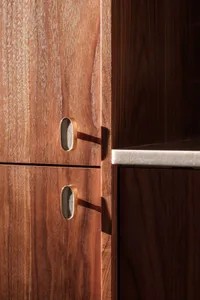 A wooden kitchen cabinet with marble handles.