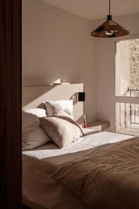A minimalist bedroom featuring soft textiles and natural light.