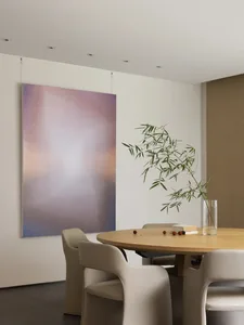 極簡室內設計，展示木製餐桌與椅子、插有竹子的花瓶，以及一幅色彩繽紛的抽象畫作