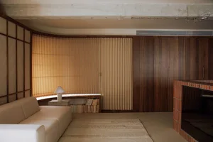 A minimalist living room with curtains and wooden paneling