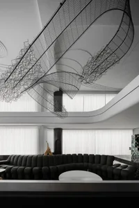 Modern black sculpture hanging from ceiling above black leather sofa