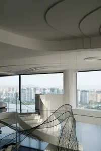 Modern interior space featuring glass and concrete walls with a cityscape view