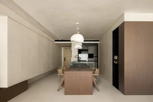 Modern kitchen and dining area with wooden table, marble countertop, and white pendant lights.