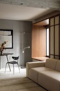A modern living room featuring a concrete wall and a wooden window bench.