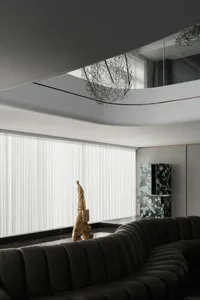 A modern living room with a glass window, leather sofa, and metal accents.