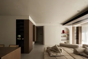 A modern living room with minimalist design, featuring a tan sectional sofa, white walls, and wooden furniture.