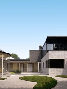 A modern residential exterior featuring brick and concrete materials.