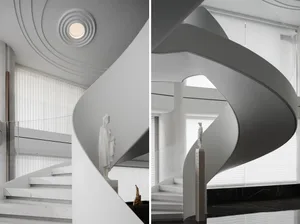 Modern interior staircase with white concrete spiral design, featuring a statue and vertical blinds.