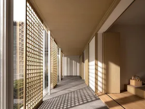 A modern corridor featuring large windows with grid-like patterns, illuminated by natural light.