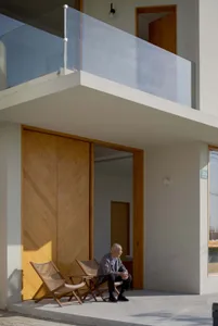 A modern architectural exterior with wooden elements and a glass balcony