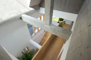 A modern interior space with concrete walls and a wooden staircase.