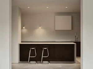 Modern and minimalist residential kitchen with sleek furniture and white countertops.