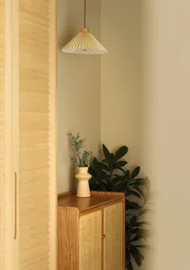 A minimalist interior design featuring a wooden cabinet with a hanging light fixture.