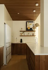 Modern kitchen featuring minimalist design with marble countertops and wooden cabinets