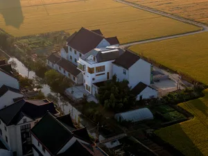 Modern house with white painted walls surrounded by fields.