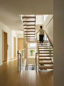 A modern interior featuring wooden stairs with glass railings.