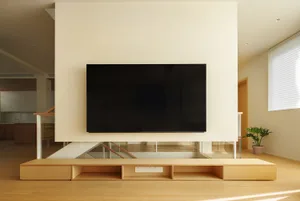 Modern living room with wooden furniture and a flat-screen TV.