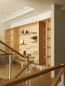 A modern living room features a wooden storage unit with built-in shelves and pegboard.